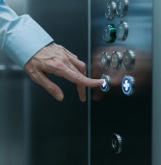 close up shot of a hand pressing an elevator button